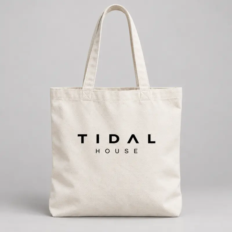 Natural canvas beach tote with the black Tidal House wordmark